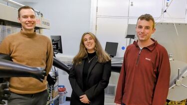 Three smiling people in a lab
