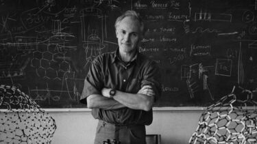 A photo of Kroto standing in front of the blackboard