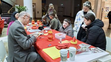 people gathered around a table making lanterns