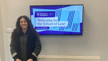 Teresa Zagr in front of a School of Law sign