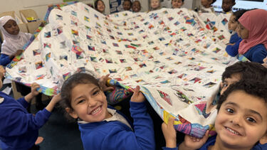 Children at Netherthorpe Primary School exploring the Quilt of Welcome