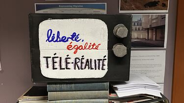 an oldfashioned television made out of cardbord reading liberté, egalite and teleralite