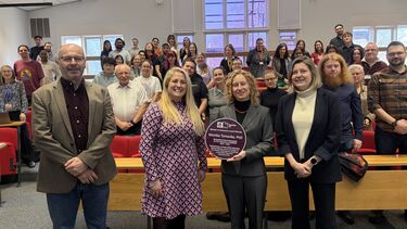 Image of Monica holding her purple plaque