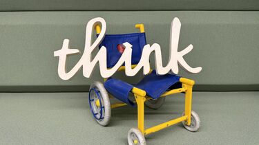 A wheelchair with the word 'think' written in white cursive text on top.