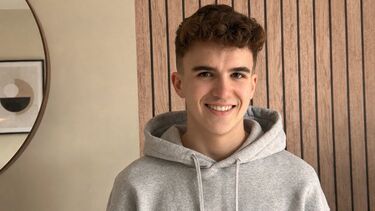Student Jake Munro-Proud stood in front of a panelled wall