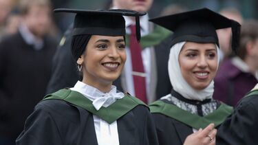 2 students wearing graduation caps and gowns