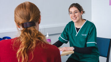 A female Pharmacy student sitting with a patient