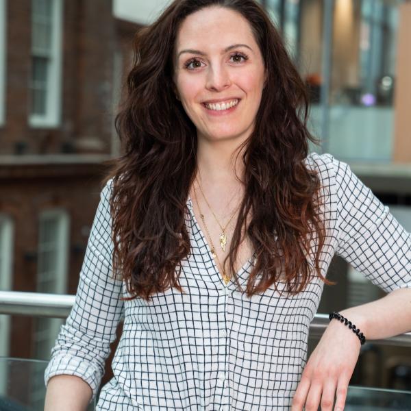 Profile picture of A photo of a white female staff member smiling at the camera. She has long dark curly hair.