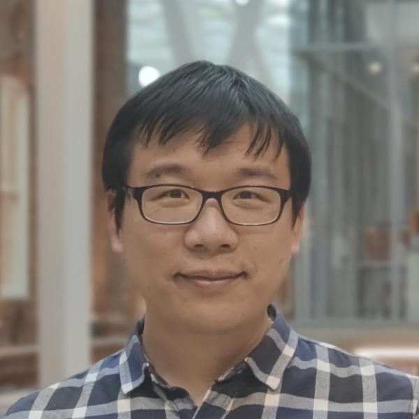 Profile picture of Image of asian man with dark hair and glasses wearing blue checked shirt. He is smiling at the camera.
