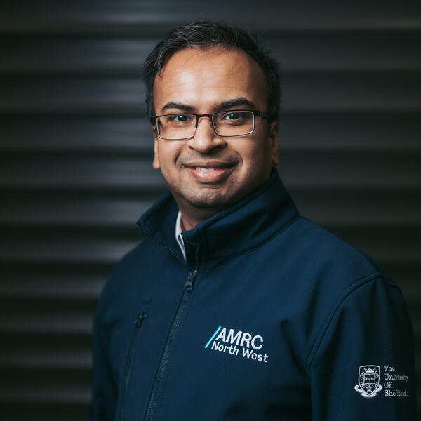 Profile picture of Headshot of man with brown hair and glasses in AMRC North West uniform