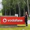 Laura Craciun, computer science alumni standing by a Vodafone sign