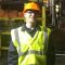 EEE student in hi vis jacket and hard hat standing at a steel works