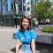 Student ambassador Sophie sitting in the sun and smiling outside Jessop West Building