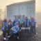 Members of the ChemEngSoc outside the first hydrogen house in the country wearing blue high vis jackets