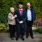 Aidan, a graduating clinical neurology student, with his parents outside a Sheffield building.
