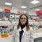 Karolina Wikaryjczyk in a lab coat, with lab equipment behind her