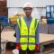 An image of our student Hasan Shwaish wearing a hi-vis vest and a hard hat as part of engineering student experience