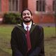 Alumni Adithya Ajith wearing graduation gown outside Firth Court