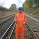 An general engineering alumnus is standing on the rail with his Network Rail uniform