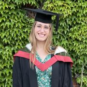 A photo of German Teaching Assistant, Rachael Norman, smiling and in Graduation attire