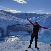Sian Thorpe with arms outstretched standing on a glacier