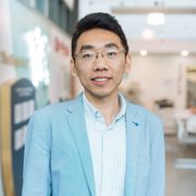 Huaiyu Li wearing a white shirt and light blue blazer.