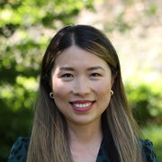 Dr Jie Tang stood outside against a green background