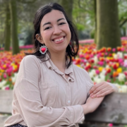 Maria Jimena Flores sat on a bench in front of flowers