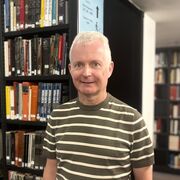 Steve stands by the book stacks in Western Bank Library 