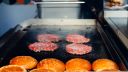 Picture of beef burgers frying on a flat hob