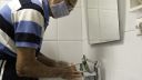 An older man washing his hands whilst wearing a face mask due to coronavirus
