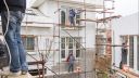 men work on scaffolding on a building site