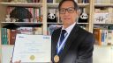 Prof Zhu wearing his IEEE Tesla medal and holding his certificate