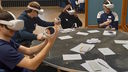 Schoolchildren sitting at a table wearing virtual reality headsets