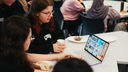 Two students looking at a video game on a laptop