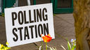 A white sign with the words polling station.