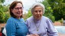 A smiling carer with an elderly woman