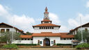 Image of a white building with red roofing and a clocktower.