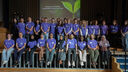 A group photo of the Grantham Scholars standing on the stage at the Sustainability Symposium 2025