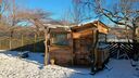 Exterior of a wooden office in the back garden with snow on the lawn