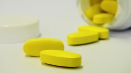A photograph of yellow tablets on a white surface.