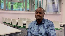 Alumnus Adamu sits in classroom being interviewed
