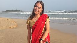 Charlotte Pritchard stood on the beach in a sari whilst on her placement abroad