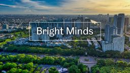 The text 'Bright Minds' over a photo of the skyline of a city with green wooded areas in the foreground and towers in the background
