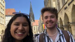 two students in Muenster in Germany. Smiling with the city in the background