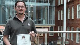 Portrait of engineering technician holding a certificate
