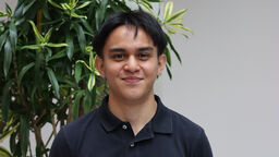 Student Asyraf Johari standing by a plant.