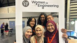 A group of six diverse women, standing inside a large frame with the text 'Women in Engineering'